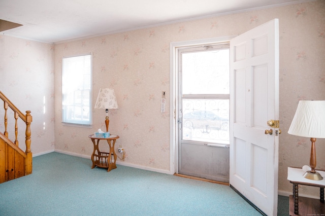 carpeted entryway featuring wallpapered walls, stairs, and baseboards