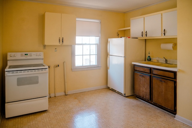 kitchen featuring a sink, white appliances, light countertops, baseboards, and light floors