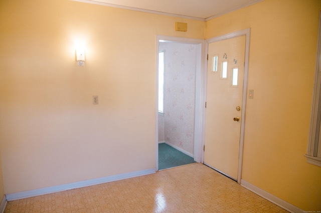 entryway with baseboards, light floors, and ornamental molding