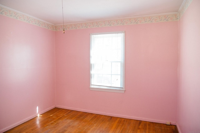 empty room featuring a wealth of natural light, light wood-type flooring, and baseboards