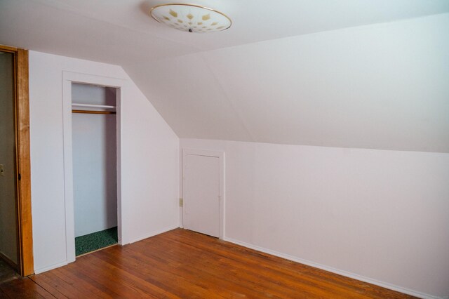 bonus room featuring baseboards, hardwood / wood-style floors, and vaulted ceiling