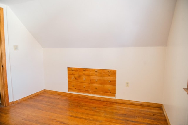 additional living space featuring vaulted ceiling, wood finished floors, and baseboards