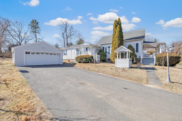 view of front of property with an outdoor structure, a garage, and covered porch