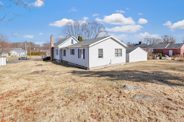 view of side of home featuring a lawn and a chimney