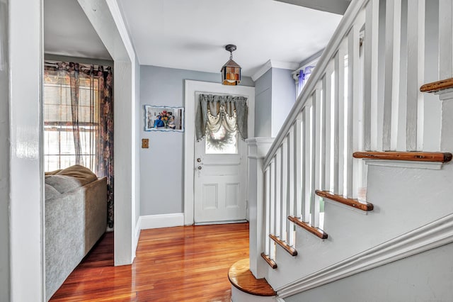 entrance foyer featuring a wealth of natural light, baseboards, wood finished floors, and stairs