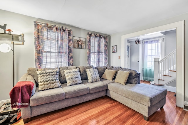 living area featuring stairway, baseboards, and wood finished floors