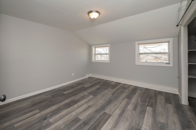 interior space with lofted ceiling, dark wood-style floors, and baseboards