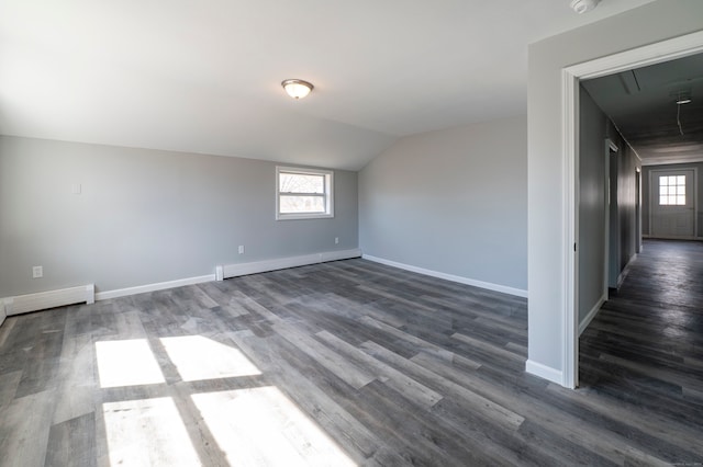 unfurnished room featuring baseboard heating, plenty of natural light, baseboards, and vaulted ceiling