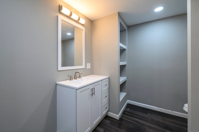 bathroom with vanity, wood finished floors, baseboards, recessed lighting, and toilet