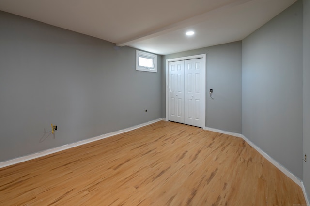 unfurnished bedroom featuring a closet, baseboards, and light wood-style floors