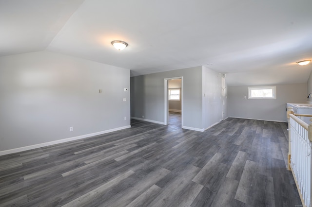 unfurnished living room featuring dark wood finished floors, a sink, baseboards, and vaulted ceiling