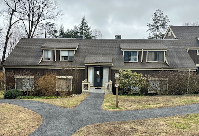 view of front of house with aphalt driveway, a shingled roof, and a front yard