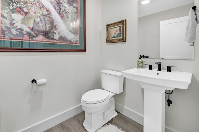 bathroom featuring baseboards, toilet, and wood finished floors