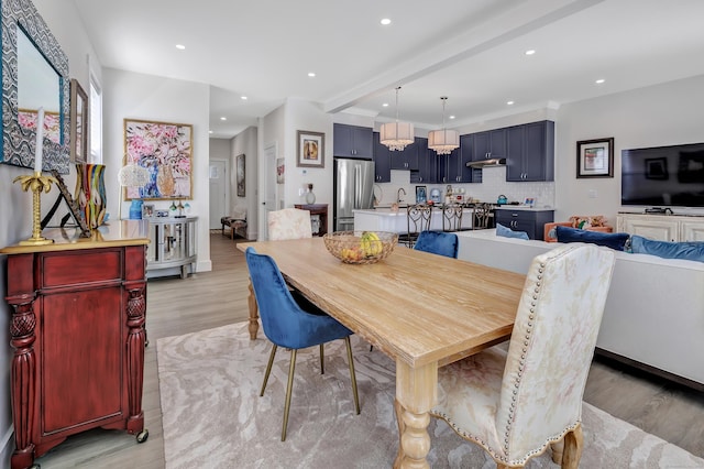 dining room with beam ceiling, recessed lighting, and light wood finished floors