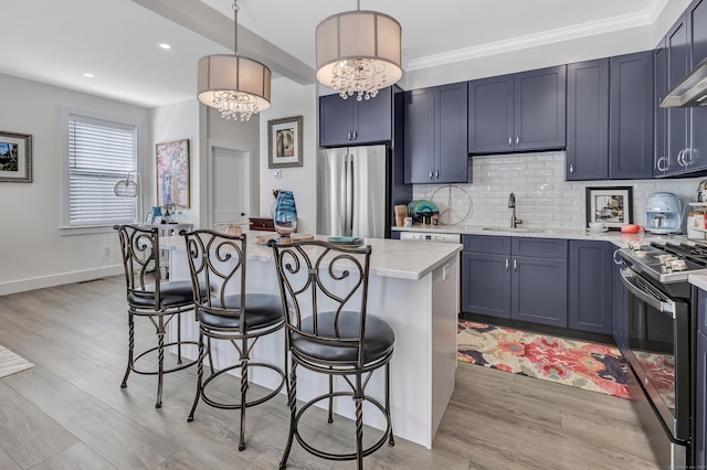 kitchen with backsplash, a breakfast bar area, light wood-style flooring, appliances with stainless steel finishes, and a sink