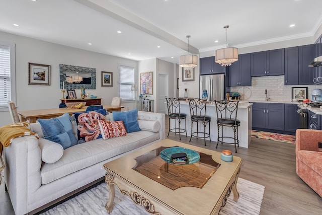 living room with recessed lighting, light wood-style floors, and ornamental molding