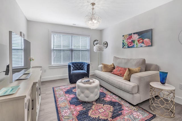 living room featuring a chandelier, visible vents, light wood finished floors, and baseboards