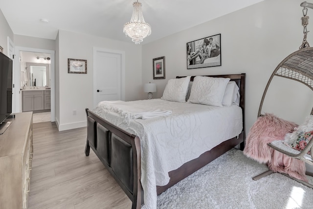 bedroom featuring light wood-style floors, baseboards, a notable chandelier, and connected bathroom