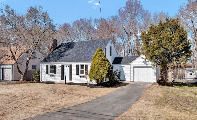 cape cod-style house featuring fence, aphalt driveway, roof with shingles, a chimney, and an attached garage