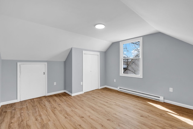 bonus room featuring wood finished floors, lofted ceiling, baseboards, and a baseboard radiator