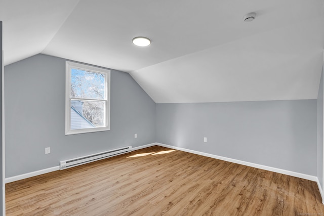 bonus room featuring vaulted ceiling, wood finished floors, baseboards, and a baseboard radiator