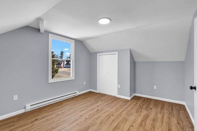 bonus room featuring lofted ceiling, wood finished floors, baseboards, and baseboard heating