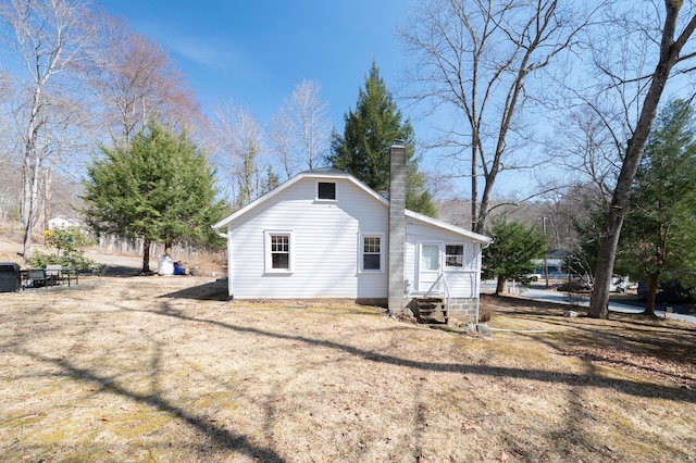 view of home's exterior featuring entry steps and a chimney