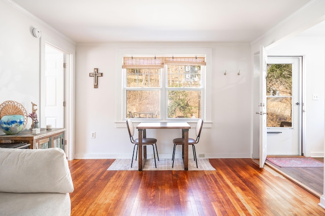 dining area with ornamental molding, baseboards, and hardwood / wood-style flooring