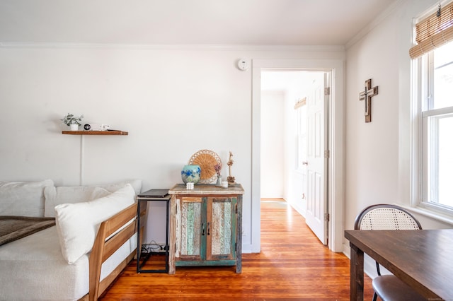 sitting room featuring a healthy amount of sunlight, wood finished floors, and crown molding