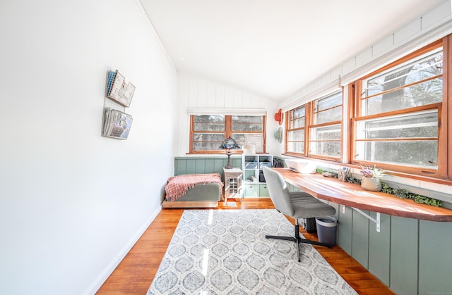 office area with vaulted ceiling, baseboards, and wood finished floors