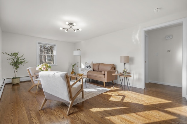 living area featuring baseboards, a notable chandelier, and wood finished floors