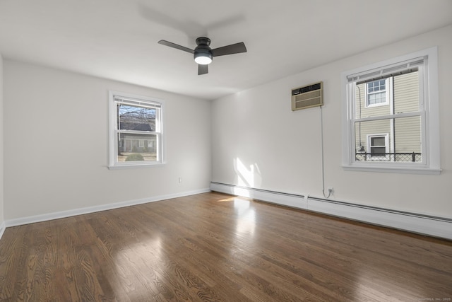 empty room with baseboards, baseboard heating, wood finished floors, a wall mounted AC, and a ceiling fan