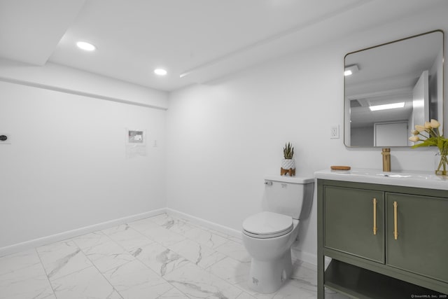 half bathroom featuring vanity, baseboards, and marble finish floor