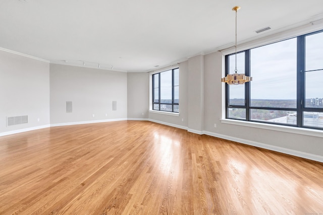 empty room featuring visible vents, light wood-style flooring, and baseboards