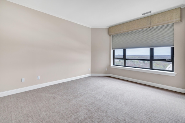 unfurnished room featuring carpet flooring, visible vents, baseboards, and ornamental molding