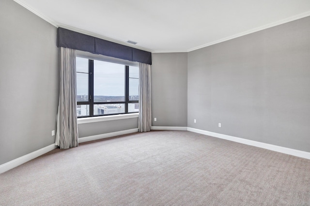 carpeted empty room with visible vents, baseboards, and ornamental molding