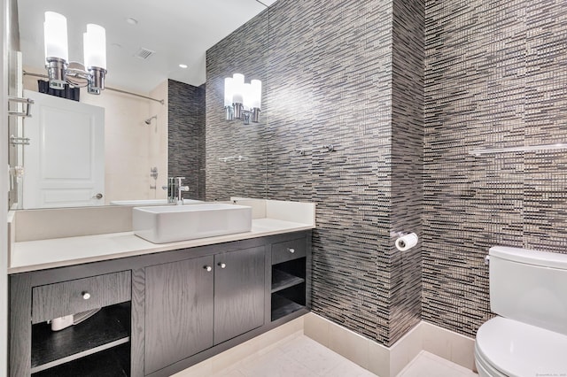 full bathroom with vanity, visible vents, walk in shower, tile walls, and toilet