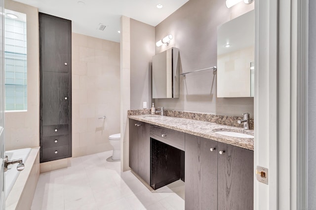 bathroom featuring a sink, toilet, a bath, and tile patterned flooring