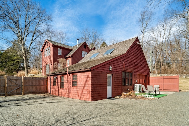 exterior space with a patio area, ac unit, fence, and a shingled roof