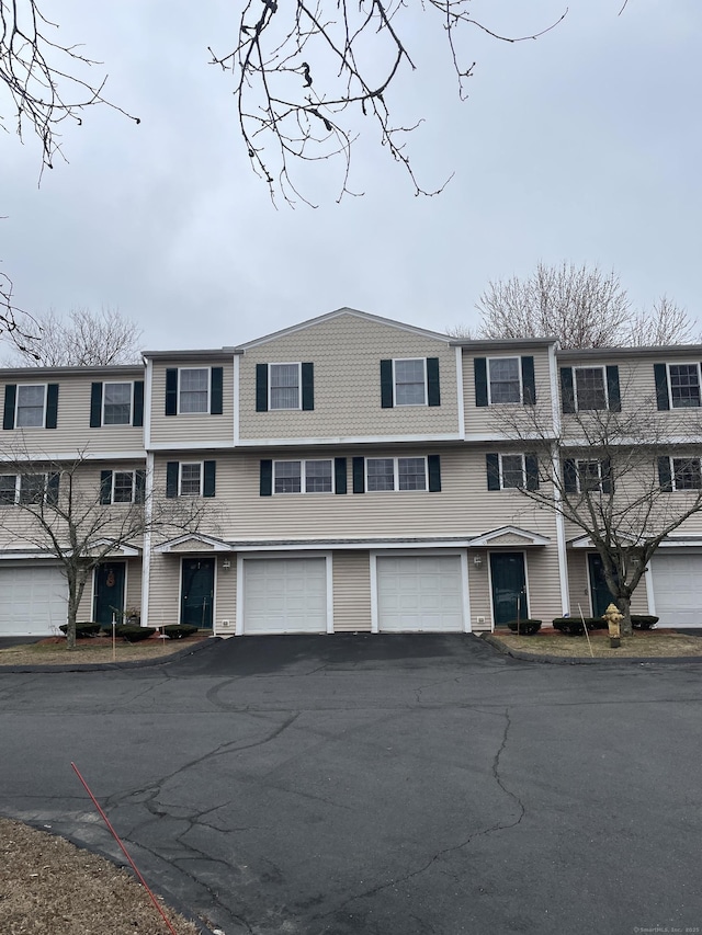 townhome / multi-family property featuring driveway and an attached garage