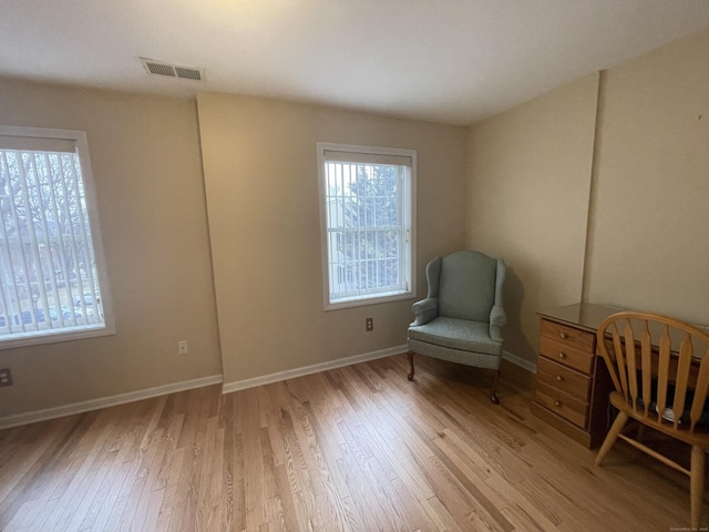 unfurnished room featuring visible vents, baseboards, and light wood-type flooring