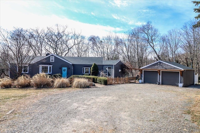 ranch-style home featuring driveway, an outdoor structure, and fence