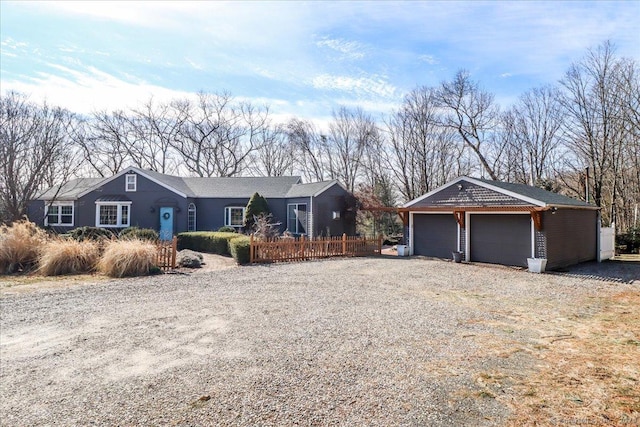 single story home featuring gravel driveway and an outdoor structure