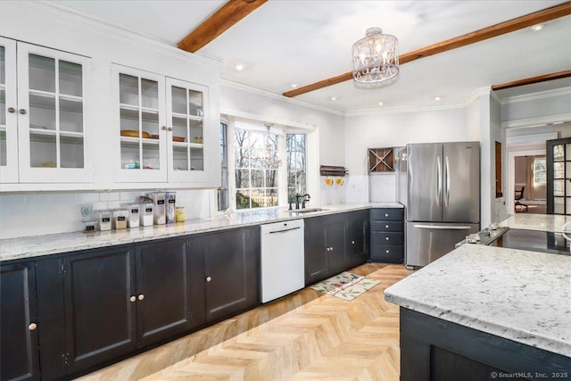 kitchen with white cabinets, white dishwasher, freestanding refrigerator, and ornamental molding