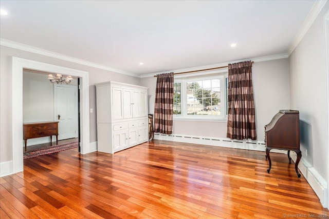 interior space with light wood-type flooring, a baseboard heating unit, recessed lighting, an inviting chandelier, and crown molding