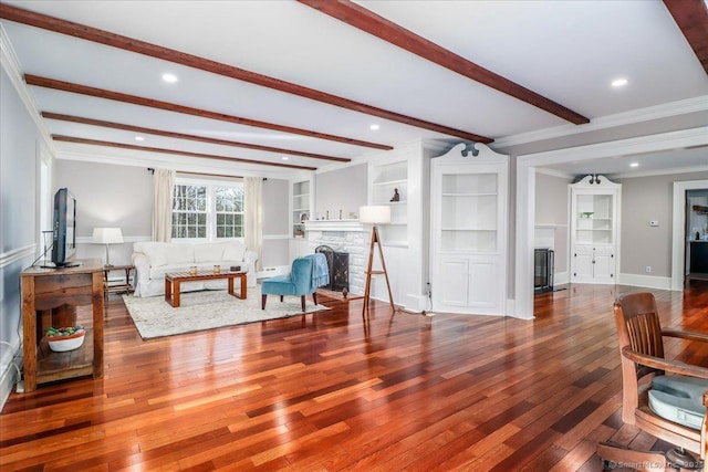 living room featuring beam ceiling, recessed lighting, wood-type flooring, a fireplace, and crown molding