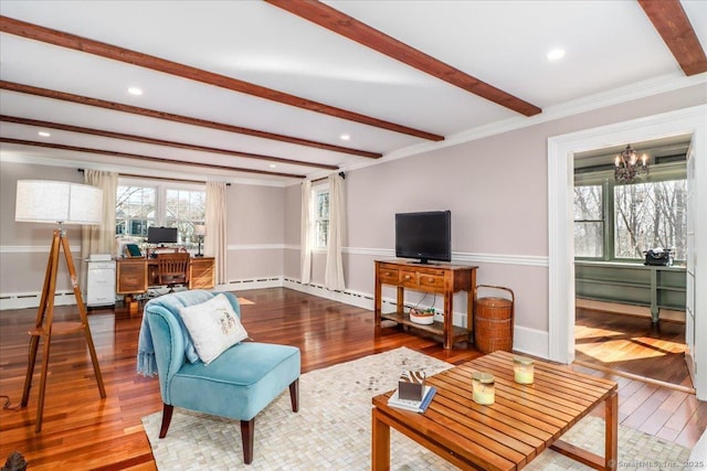 living area with hardwood / wood-style flooring, beamed ceiling, ornamental molding, and a chandelier