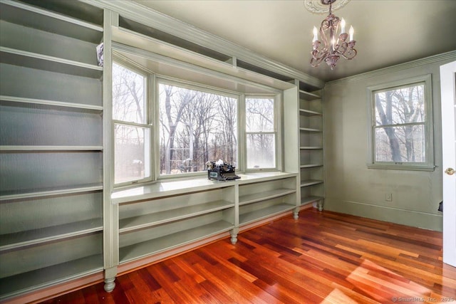 dining space with baseboards, plenty of natural light, an inviting chandelier, and wood finished floors