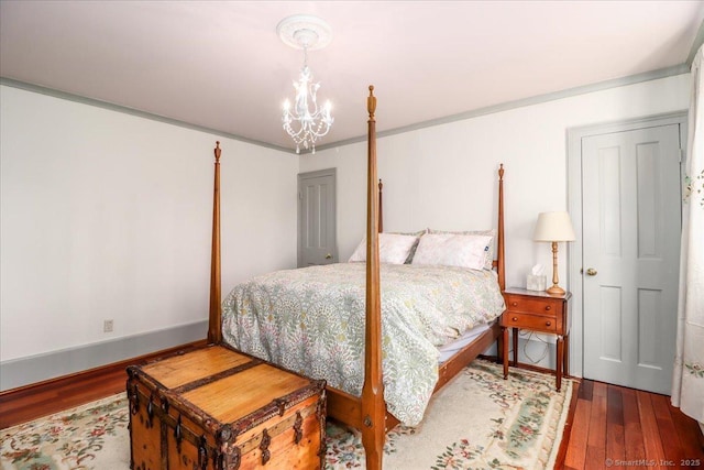 bedroom featuring baseboards, wood finished floors, and a chandelier