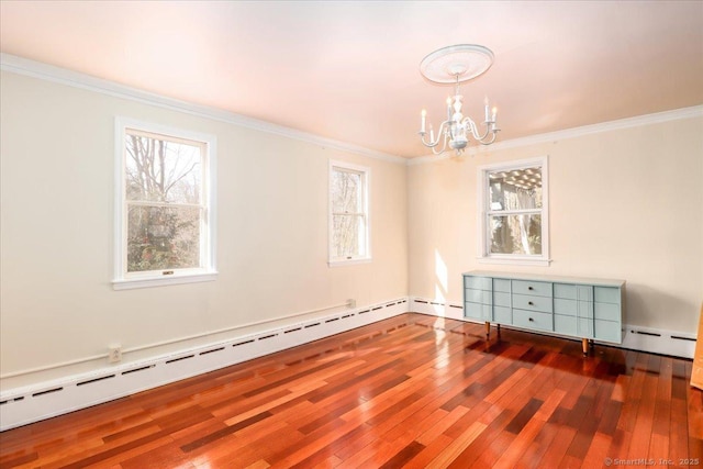 empty room featuring hardwood / wood-style floors, crown molding, a notable chandelier, and baseboard heating